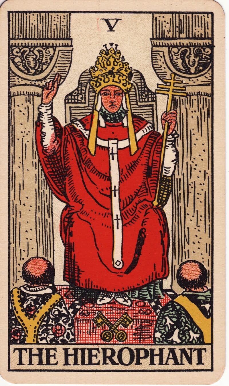 Carta de El Hierofante — figura entre dos pilares bendiciendo a dos suplicantes arrodillados, baraja Rider-Waite-Smith