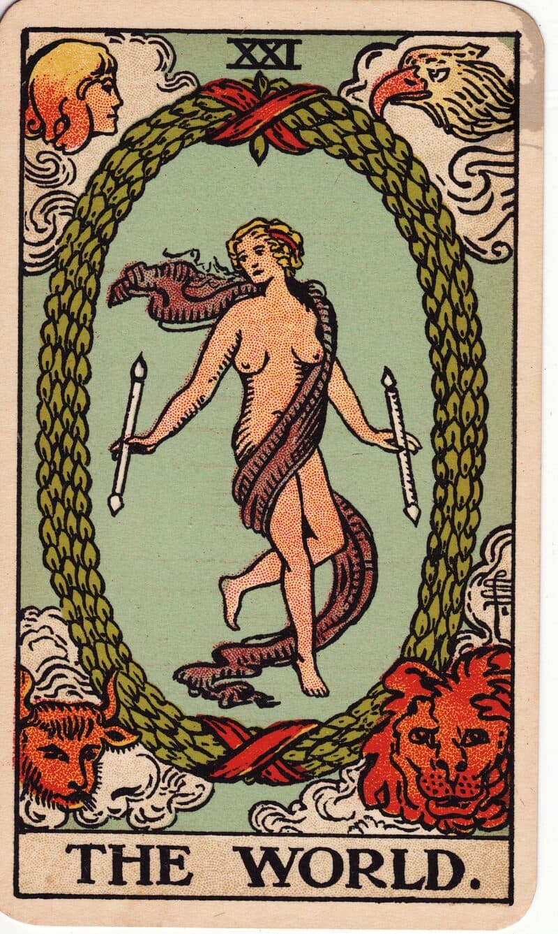 Carta de El Mundo — figura danzando dentro de una corona de laurel rodeada de cuatro criaturas aladas, baraja Rider-Waite-Smith